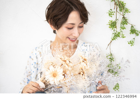 Beauty image (middle-aged woman with short hair holding dried flowers) Beauty image (middle-aged woman with short hair holding dried flowers) 122346994