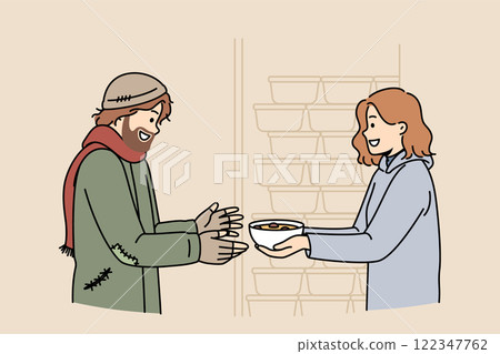 Woman volunteer feeds homeless man who came to shelter for help and hot meals, standing near plates Woman volunteer feeds homeless man who came to shelter for help and hot meals, standing near plates 122347762