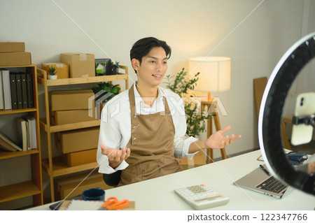 An entrepreneur in an apron live streaming session to promote and sell his products An entrepreneur in an apron live streaming session to promote and sell his products 122347766