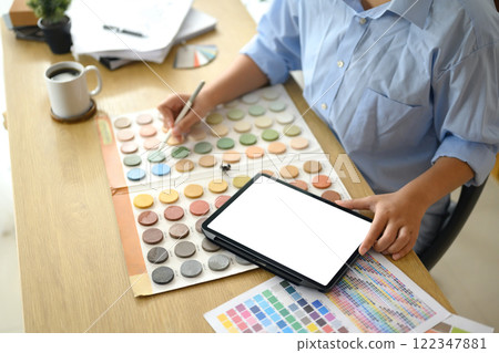 Interior designer using digital tablet and selecting a color from the palette Interior designer using digital tablet and selecting a color from the palette 122347881