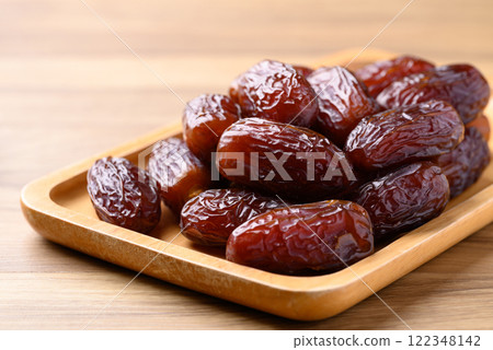 Date palm fruit (MedJool) on wooden plate 122348142