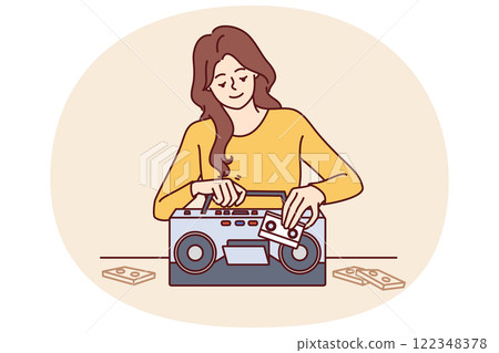 Woman inserts tape cassette into player to turn on music and start party in retro style 122348378