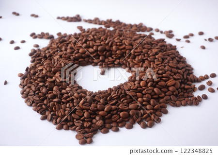 A creative arrangement of roasted coffee beans forming a perfect circular shape on a white background, showcasing their rich brown color, texture, and connection to coffee culture and artistic design. A creative arrangement of roasted coffee beans forming a perfect circular shape on a white background, showcasing their rich brown color, texture, and connection to coffee culture and artistic design. 122348825