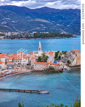 The terrace offers a breathtaking view of the Old Town of Budva, where stone walls and ancient towers combine with the vibrant sea horizon and picturesque landscapes. The terrace offers a breathtaking view of the Old Town of Budva, where stone walls and ancient towers combine with the vibrant sea horizon and picturesque landscapes. 122349192