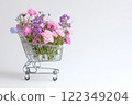 Shopping cart with summer flowers on white background 122349204