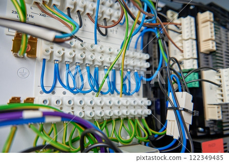 Colorful wires and components connected to terminal block in distribution box. Electrical circuit board with wiring and connections Colorful wires and components connected to terminal block in distribution box. Electrical circuit board with wiring and connections 122349485