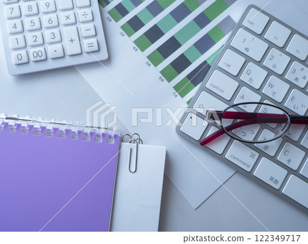 Graphs, keyboard, glasses, documents, notebook and calculator on the table 122349717