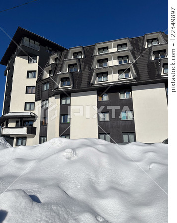 New modern block of flats in green area at winter. residential apartment with flat buildings exterior. luxury house complex covered snow. City Real estate property condo architecture insurance concept 122349897