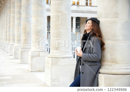 Elegant woman savoring coffee in a Parisian colonnade. Elegant woman savoring coffee in a Parisian colonnade. 122349986