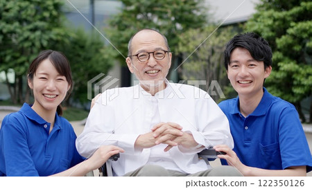 Smiling caregiver and elderly person in wheelchair Smiling caregiver and elderly person in wheelchair 122350126