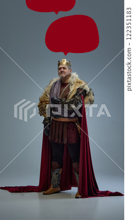 Art collage. Medieval king in golden crown, fur-lined cloak, and armor standing on grey background surrounded by red speech bubbles for text placement. Art collage. Medieval king in golden crown, fur-lined cloak, and armor standing on grey background surrounded by red speech bubbles for text placement. 122351183