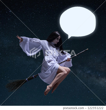 Witch with black hair, in flowing white dress sits on broom and flies in starry sky with a speech bubble ready for custom text. 122351222