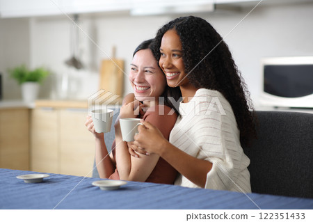 Happy interracial couple hugging drinking and contemplating 122351433