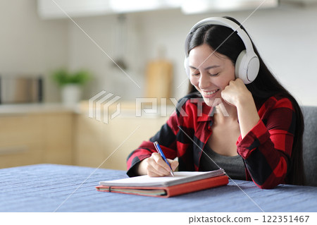 Happy asian student learning with headphone at home 122351467