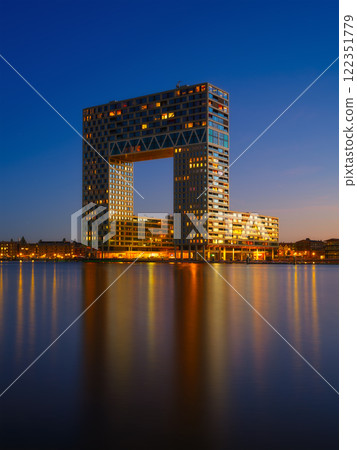 Amsterdam, Netherlands. A cityscape during sunset. Dark sky and city lights. Dutch canals. Amsterdam, Netherlands. A cityscape during sunset. Dark sky and city lights. Dutch canals. 122351779
