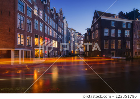 Damrak, Amsterdam, Netherlands. View of houses during sunset. The famous Dutch canals. Damrak, Amsterdam, Netherlands. View of houses during sunset. The famous Dutch canals. 122351780