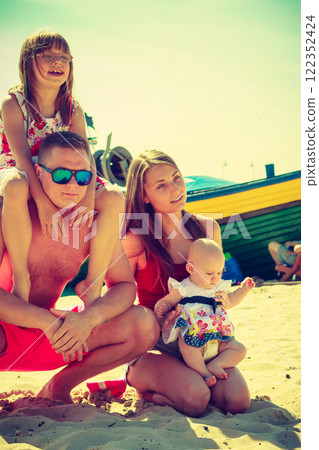Family posing at beach near sea 122352424