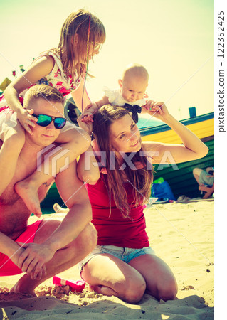 Family posing at beach near sea 122352425