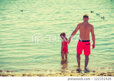 Man and girl walking in water 122352426