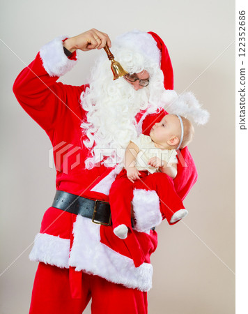 Man wearing santa claus costume holding baby Man wearing santa claus costume holding baby 122352686