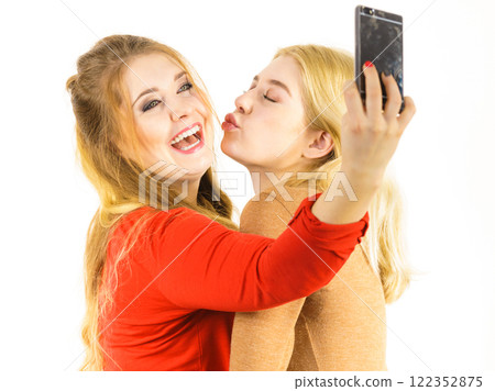 Two women taking selfie using smartphone 122352875