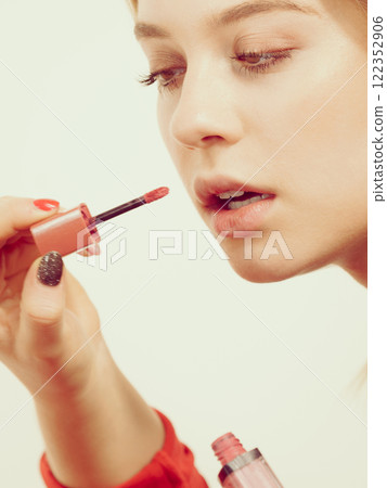 Woman applying lipstick or lip gloss Woman applying lipstick or lip gloss 122352906