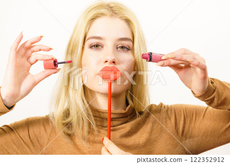 Woman applying lipstick or lip gloss 122352912