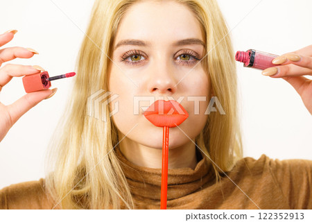 Woman applying lipstick or lip gloss 122352913