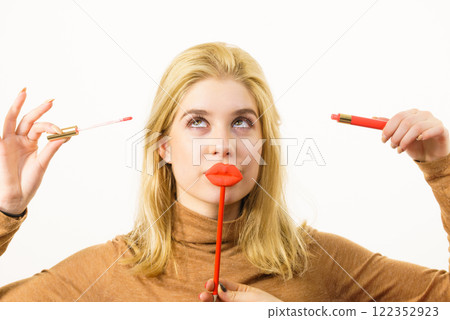 Woman applying lipstick or lip gloss Woman applying lipstick or lip gloss 122352923