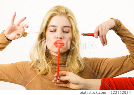 Woman applying lipstick or lip gloss Woman applying lipstick or lip gloss 122352924