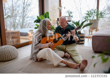 Husband teaching his wife to play on guitar, spending time together. Husband teaching his wife to play on guitar, spending time together. 122353191