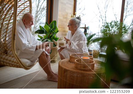 Cup of tea after a spa session. Seniors sitting in a relaxation room. 122353209