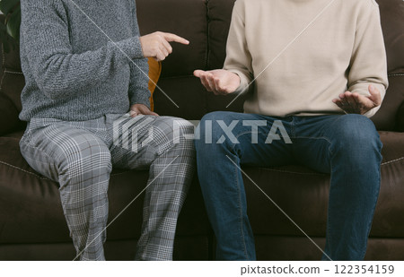 couple of men arguing sitting on a brown sofa couple of men arguing sitting on a brown sofa 122354159