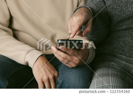 man shows something in his smartphone to his partner man shows something in his smartphone to his partner 122354160