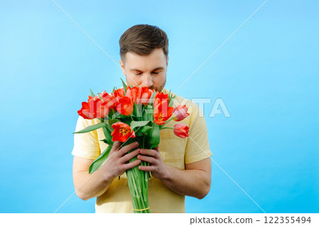Man holding bouquet of red tulips Man holding bouquet of red tulips 122355494