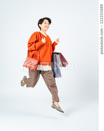 中年婦女提著購物袋跳的全身照片 122355889