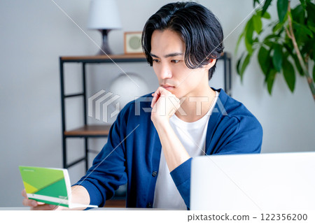 一個男人看著他的銀行存摺 122356200