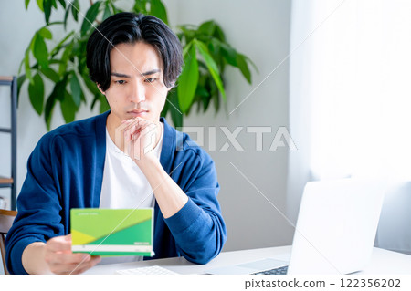 一個男人看著他的銀行存摺 一個男人看著他的銀行存摺 122356202