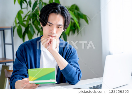 一個男人看著他的銀行存摺 一個男人看著他的銀行存摺 122356205