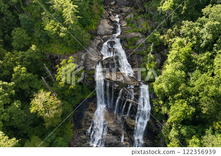 Beautiful landscape of high waterfall with falling down clear water from rocky boulders between green lush woods. Whitewater Falls in Nantahala National Forest, North Carolina, USA Beautiful landscape of high waterfall with falling down clear water from rocky boulders between green lush woods. Whitewater Falls in Nantahala National Forest, North Carolina, USA 122356939