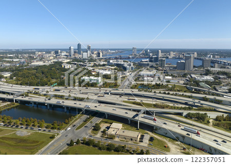Aerial view of Jacksonville city with high office buildings and american freeway intersection with fast driving cars and trucks. View from above of USA transportation infrastructure Aerial view of Jacksonville city with high office buildings and american freeway intersection with fast driving cars and trucks. View from above of USA transportation infrastructure 122357051
