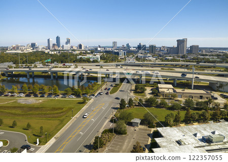 Aerial view of Jacksonville city with high office buildings and american freeway intersection with fast driving cars and trucks. View from above of USA transportation infrastructure Aerial view of Jacksonville city with high office buildings and american freeway intersection with fast driving cars and trucks. View from above of USA transportation infrastructure 122357055