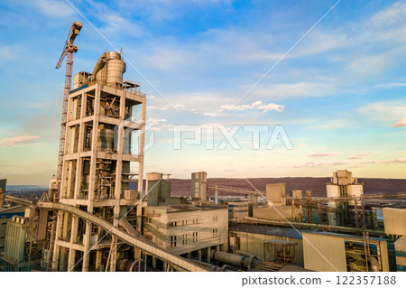 Aerial view of cement plant with high factory structure and tower crane at industrial production area. Aerial view of cement plant with high factory structure and tower crane at industrial production area. 122357188