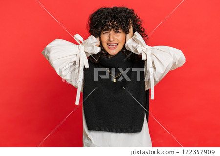 Annoyed irritated woman covering ears gesturing no avoiding advice ignoring noise loud voices 122357909