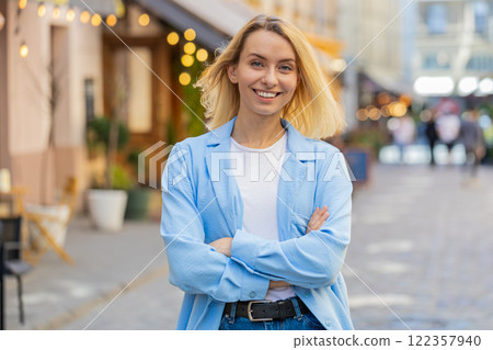 Happy blonde woman smiling looking away dreaming resting good news feel satisfied on city street 122357940
