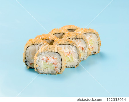 Studio photography of Hot philadelphia roll with cucumber and salmon wrapped in nori. Isolated on solid light blue background. Sushi Perfection with Hot tempura roll 122358034