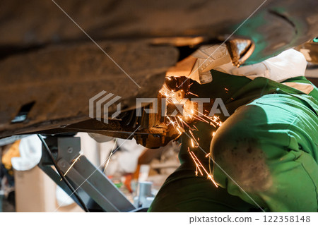 Mechanic Welding Underneath a Vehicle in a Workshop Mechanic Welding Underneath a Vehicle in a Workshop 122358148