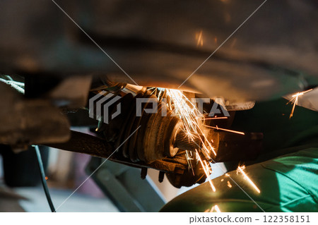 Dynamic Close-Up of a Welder Creating Sparks While Repairing a Vehicle's Suspension System Dynamic Close-Up of a Welder Creating Sparks While Repairing a Vehicle's Suspension System 122358151