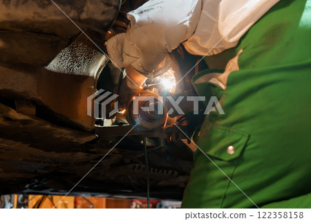 Mechanic Performing Detailed Maintenance Underneath a Vehicle Mechanic Performing Detailed Maintenance Underneath a Vehicle 122358158