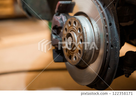 Close-up of a Car Brake Disc and Caliper in a Mechanical Workshop 122358171